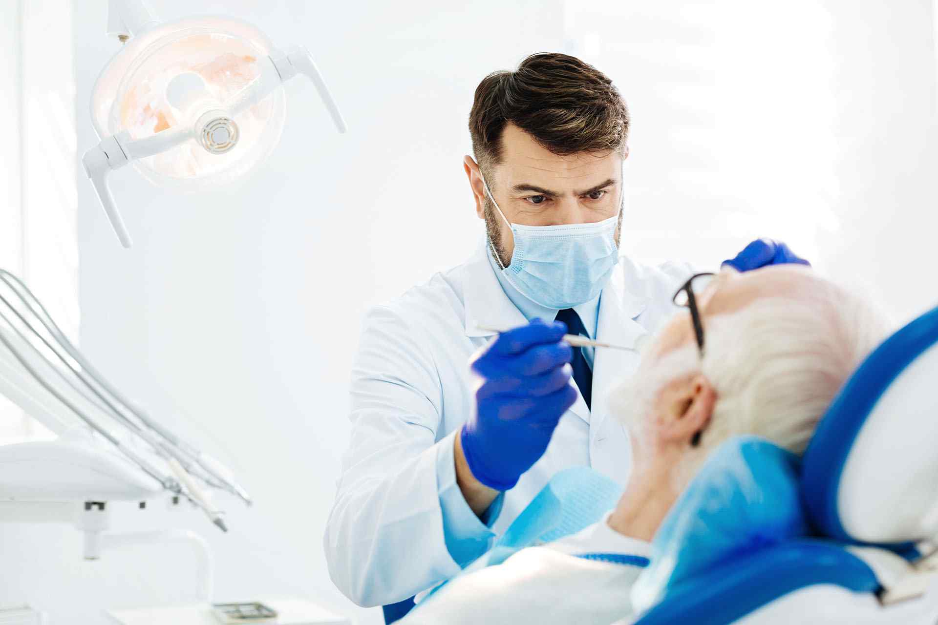 A dentist is examining the patient teeth during treatment