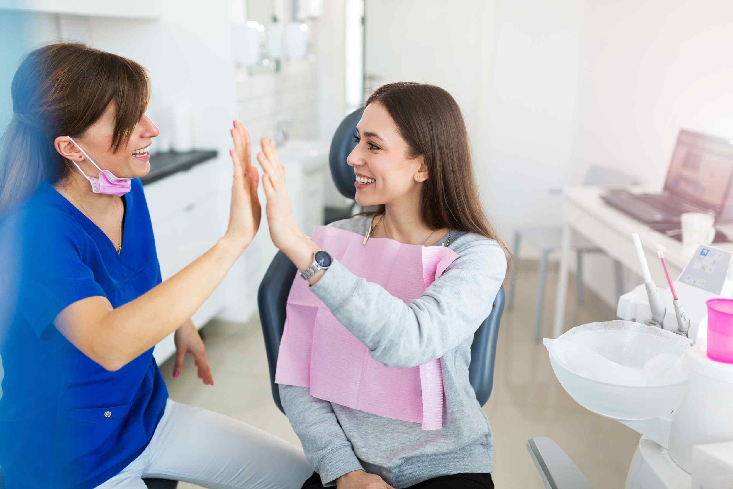 Two women giving each other a high five after treatment.