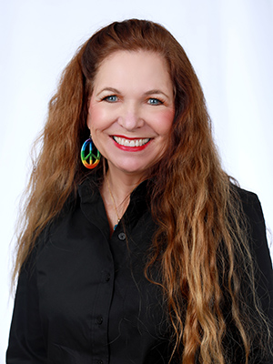A woman with long red hair and big smile.